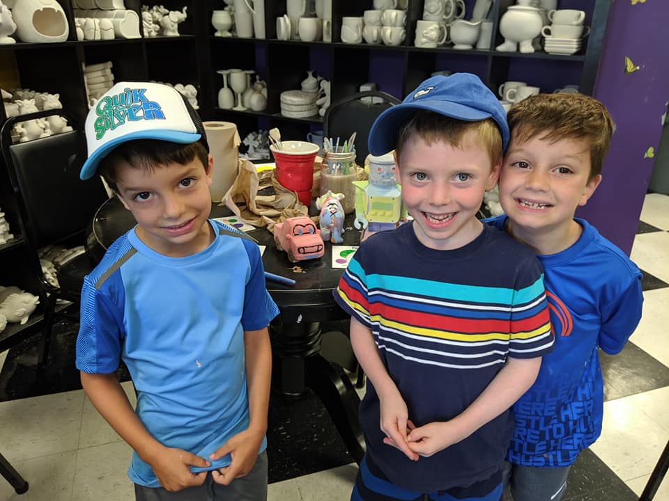 Three kids inside the pottery studio