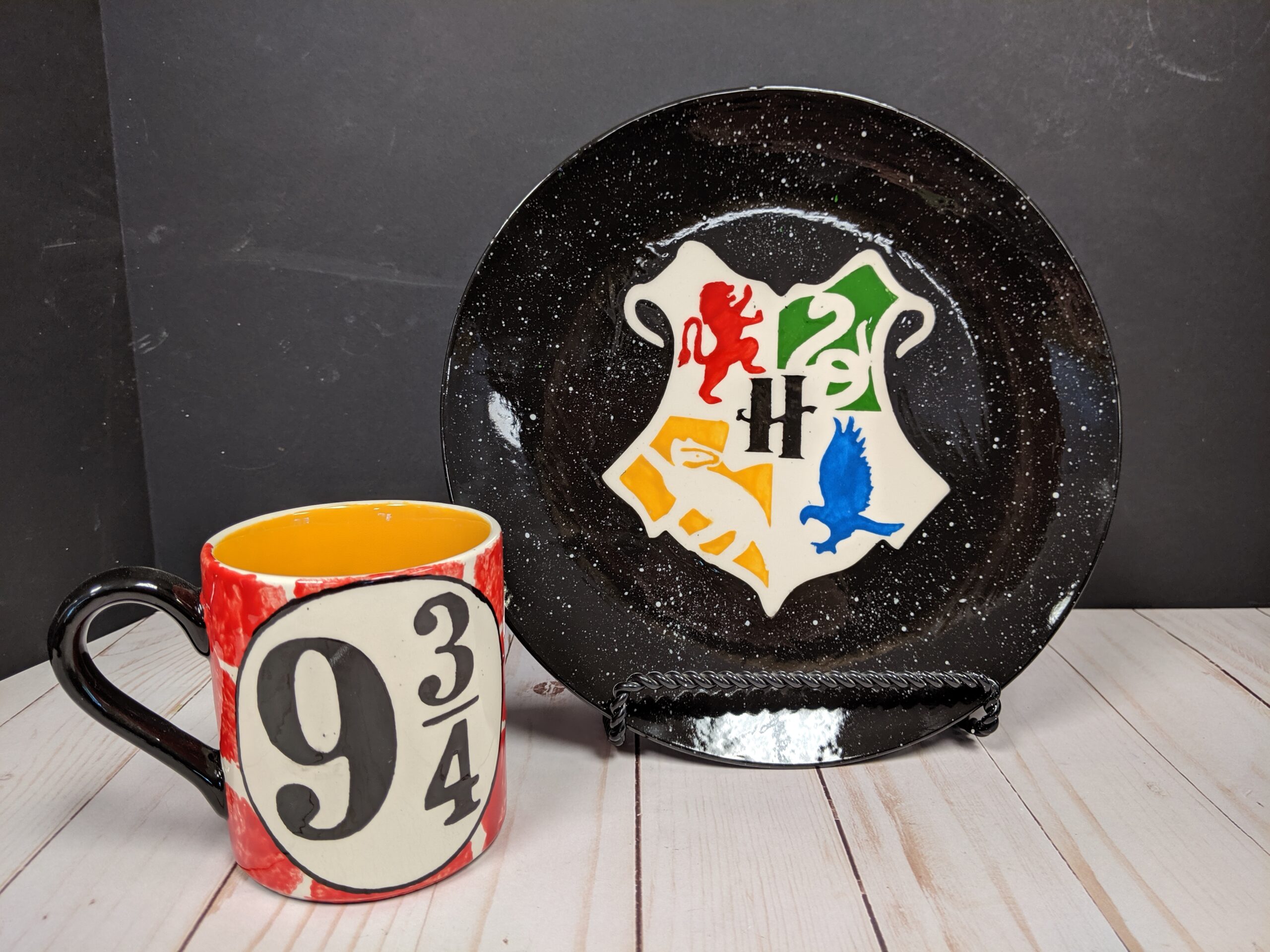 A plate and mug with the hogwarts house colors on them.