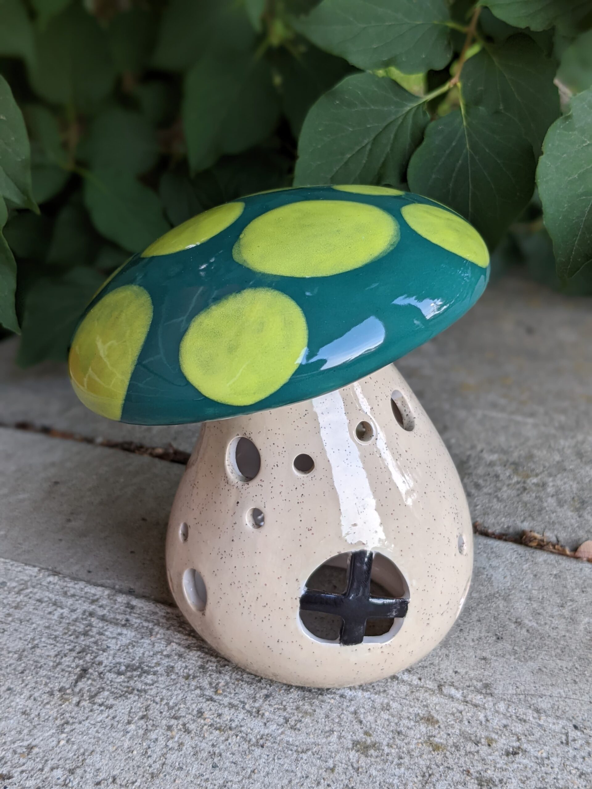 A ceramic mushroom sitting on top of the ground.