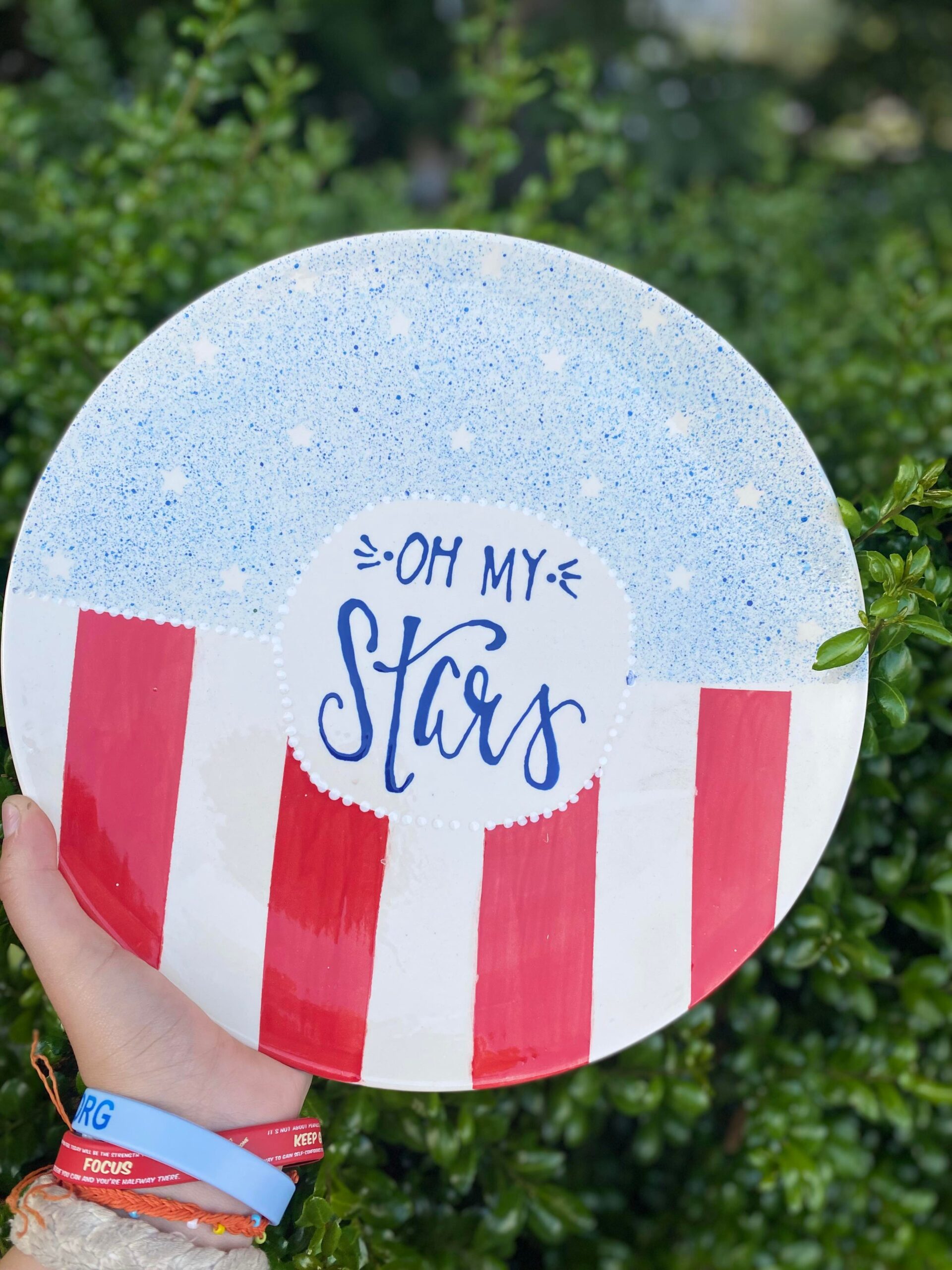 A hand holding up a plate with the words " oh my stars ".