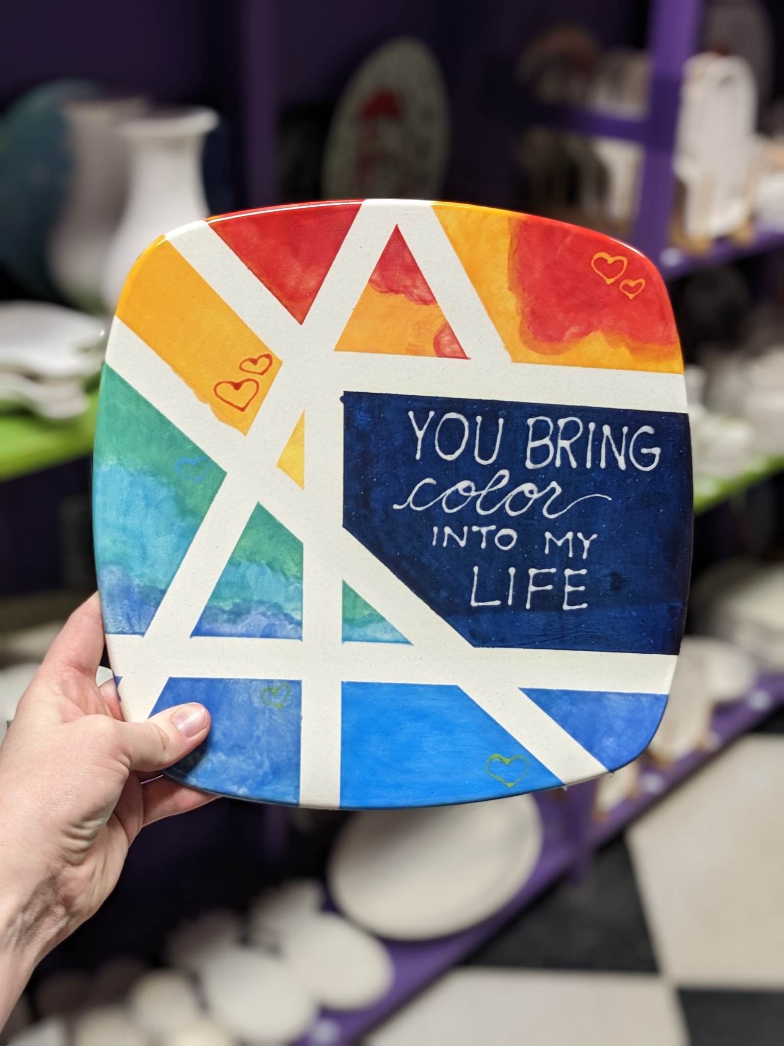 A person holding up a plate with the words " you bring color into my life ".