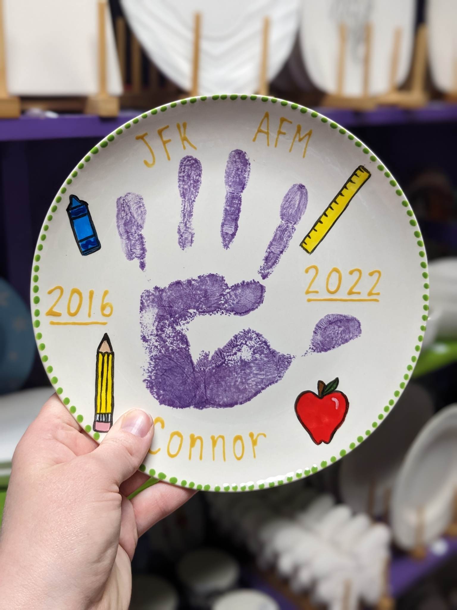 A hand print plate with the name of a child 's school.