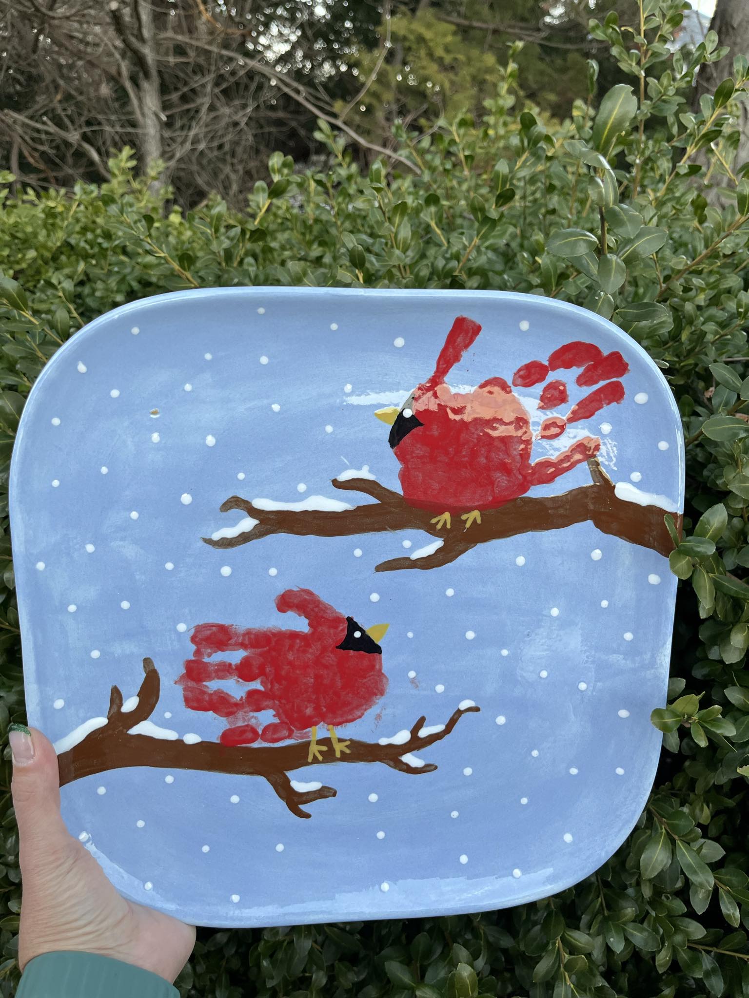 A plate with handprints of two birds on it.