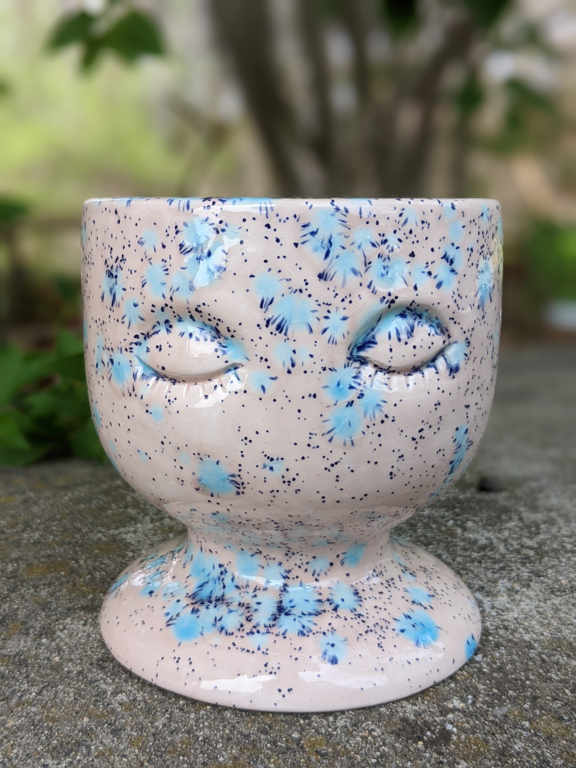 A ceramic cup with blue speckles on it